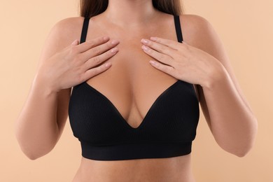 Photo of Woman with beautiful breast on beige background, closeup