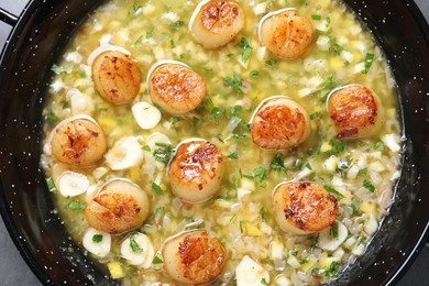 Photo of Fried scallops with sauce in dish on grey table, top view