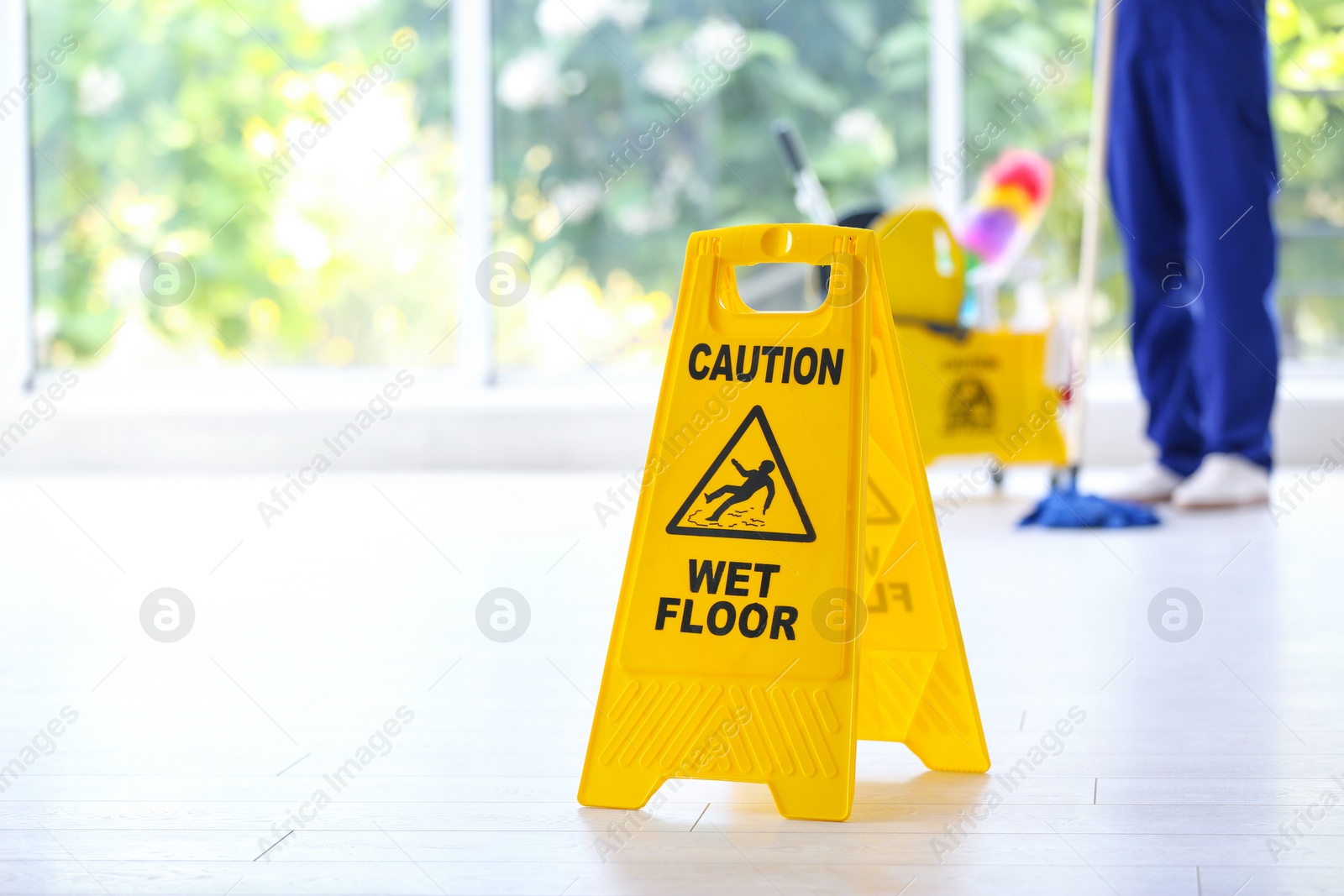 Photo of Safety sign with phrase Caution wet floor and cleaner indoors. Cleaning service