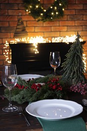 Photo of Plates, glasses and festive decor on wooden table