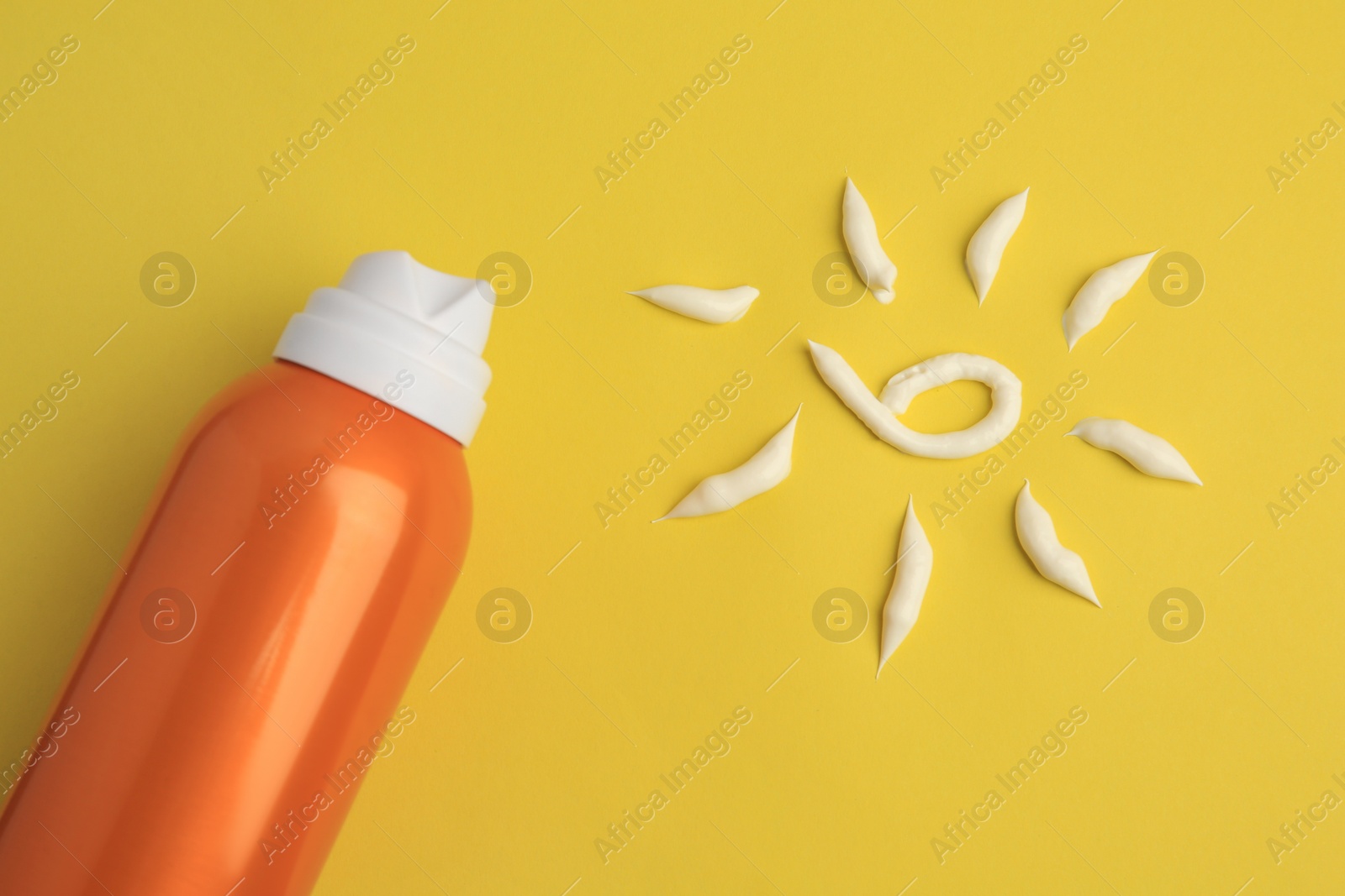 Photo of Drawing of sun and bottle with sunscreen on yellow background, top view. Skin protection