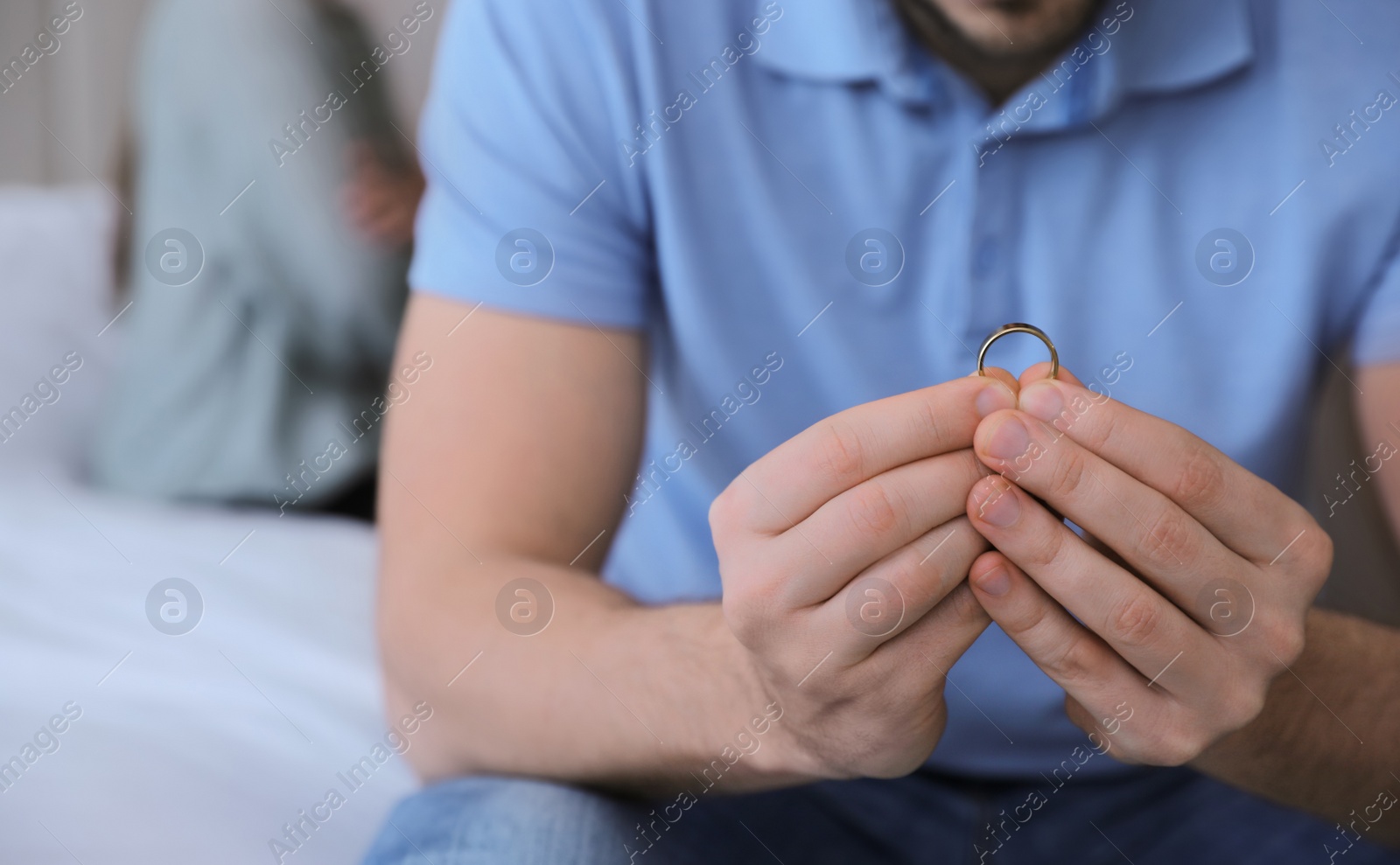 Photo of Man with wedding ring in bedroom, closeup. Couple on verge of divorce