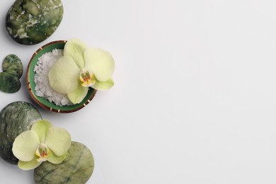 Photo of Flat lay composition with spa stones, salt and beautiful flowers on white table. Space for text