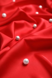 Many beautiful pearls on delicate red silk