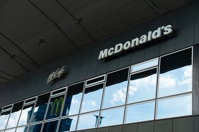 Photo of WARSAW, POLAND - SEPTEMBER 04, 2022: McDonald's Restaurant and McCafe logos on building facade, low angle view