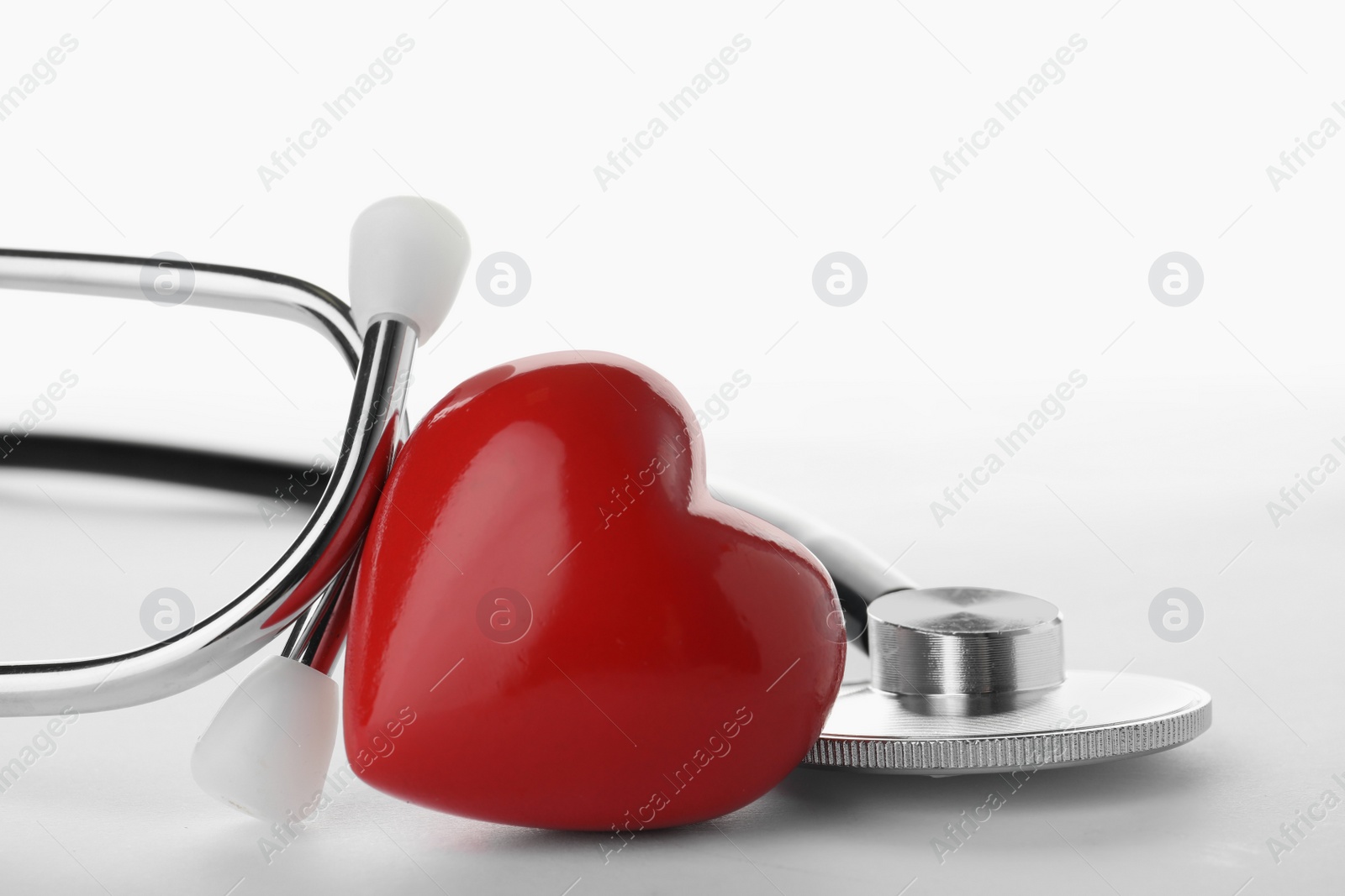 Photo of Stethoscope with heart on white background, closeup