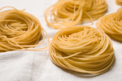 Photo of Capellini pasta on white tablecloth, closeup view