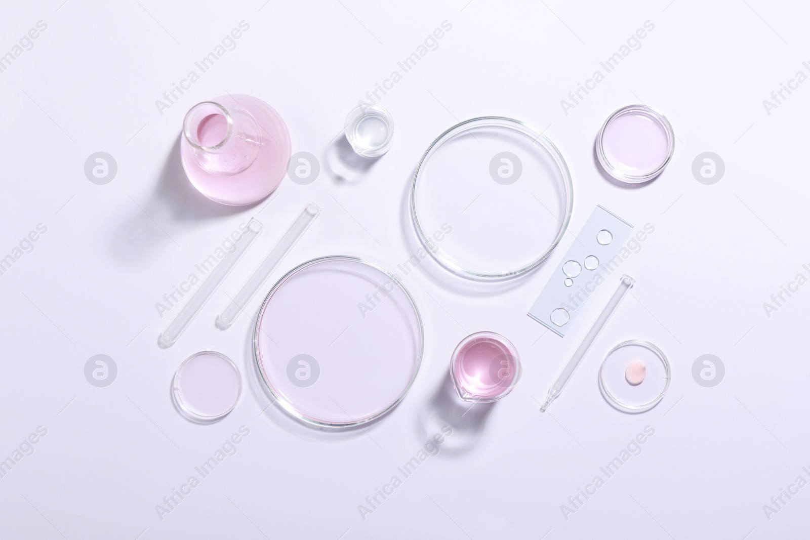 Photo of Organic cosmetic product and laboratory glassware on white background, top view