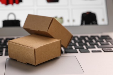 Photo of Mini boxes on laptop, closeup. Online store