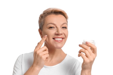 Photo of Mature woman applying face cream on white background