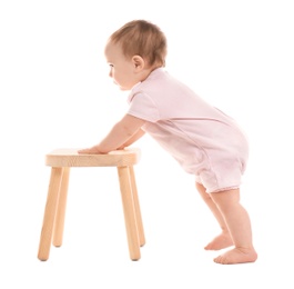 Photo of Cute baby holding on to wooden stool on white background. Learning to walk