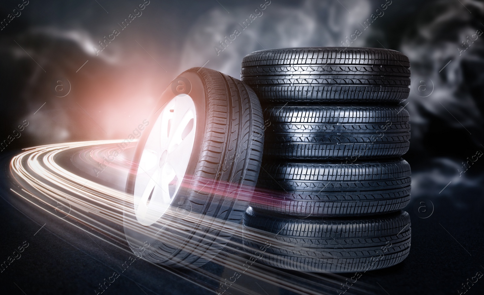 Image of Car tires and smoke on road against black background