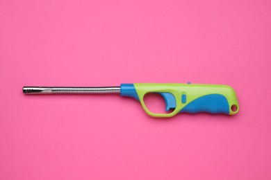 One gas lighter on pink background, top view