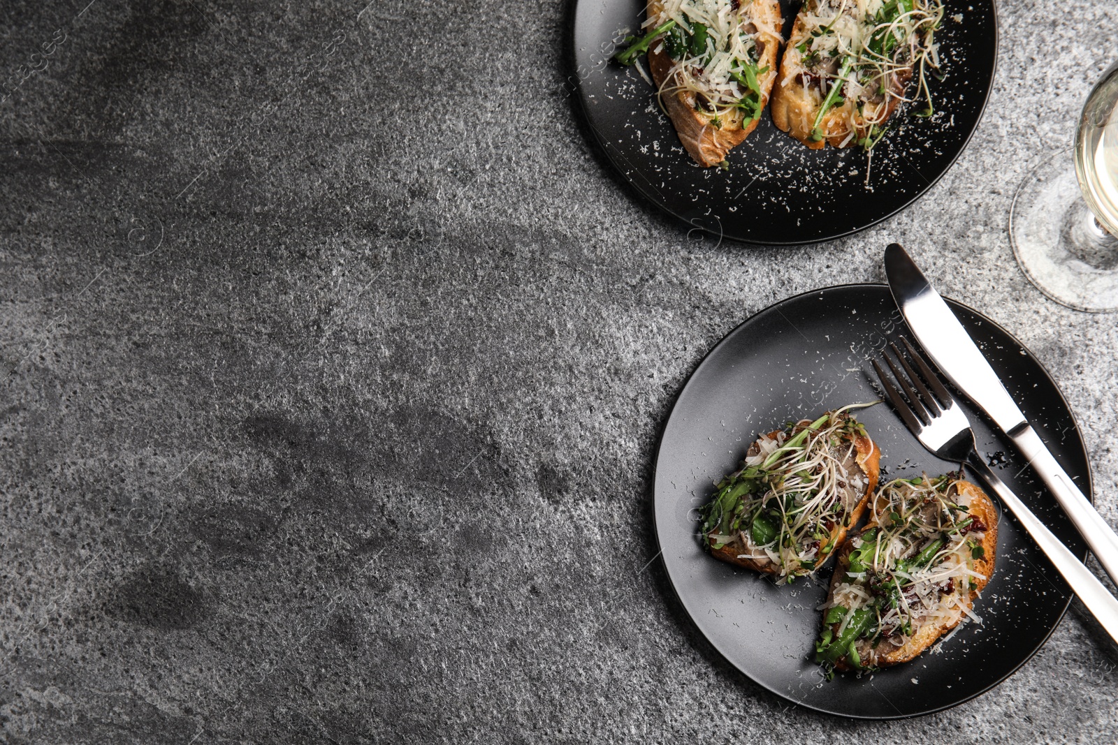 Photo of Flat lay composition with delicious bruschettas on grey table. Space for text