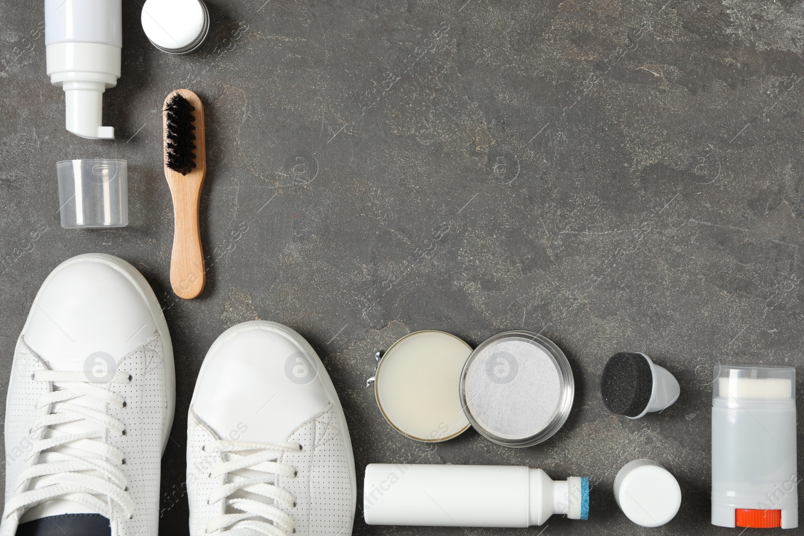 Photo of Flat lay composition with stylish footwear and shoe care accessories on grey background, space for text