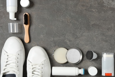 Flat lay composition with stylish footwear and shoe care accessories on grey background, space for text