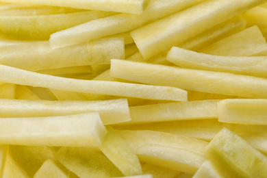 Photo of Raw white carrot sticks as background, closeup