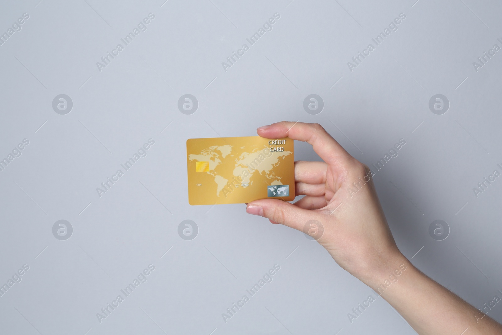 Photo of Woman holding credit card on light grey background, closeup