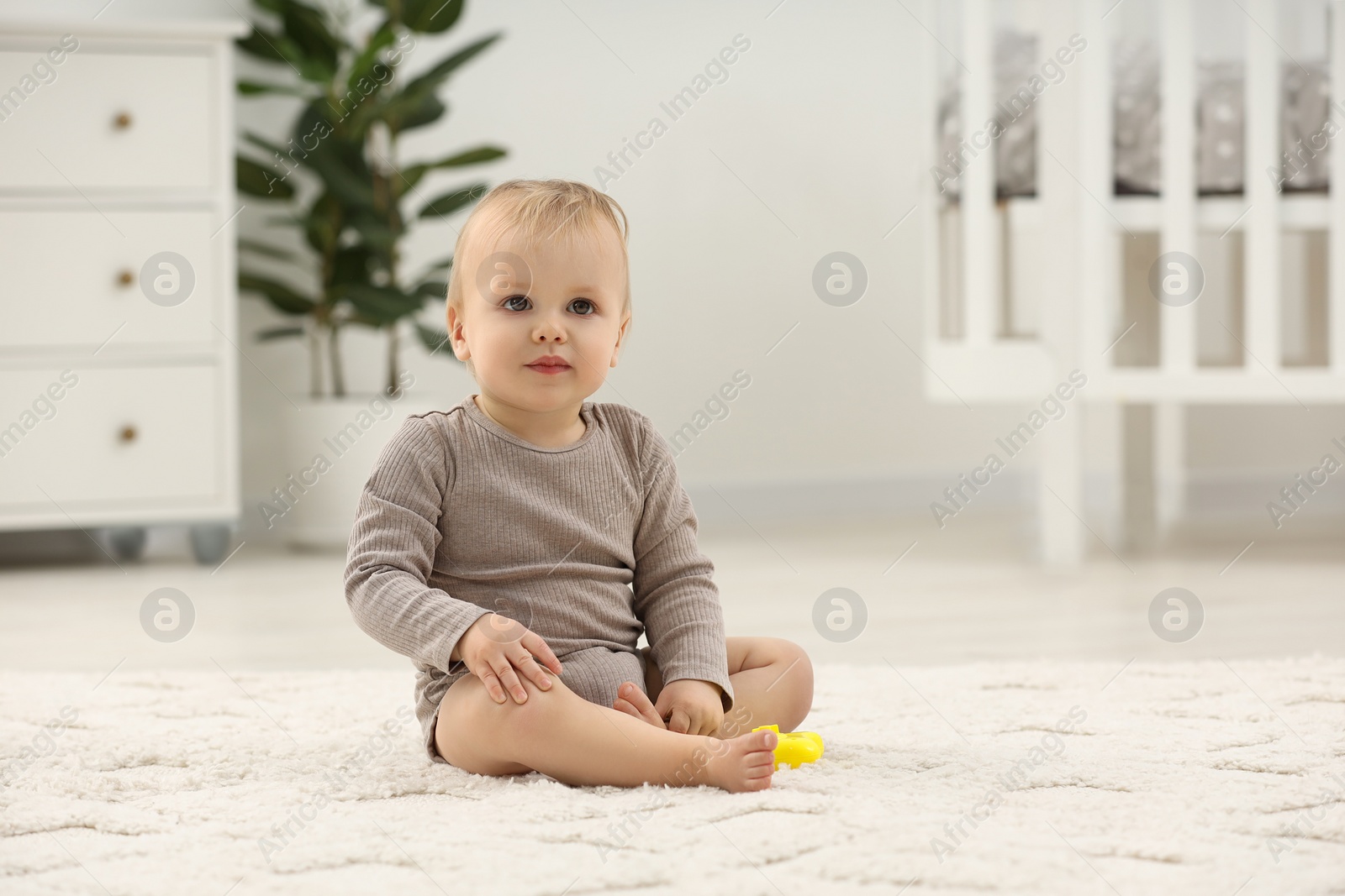 Photo of Children toys. Cute little boy with colorful toy on rug at home