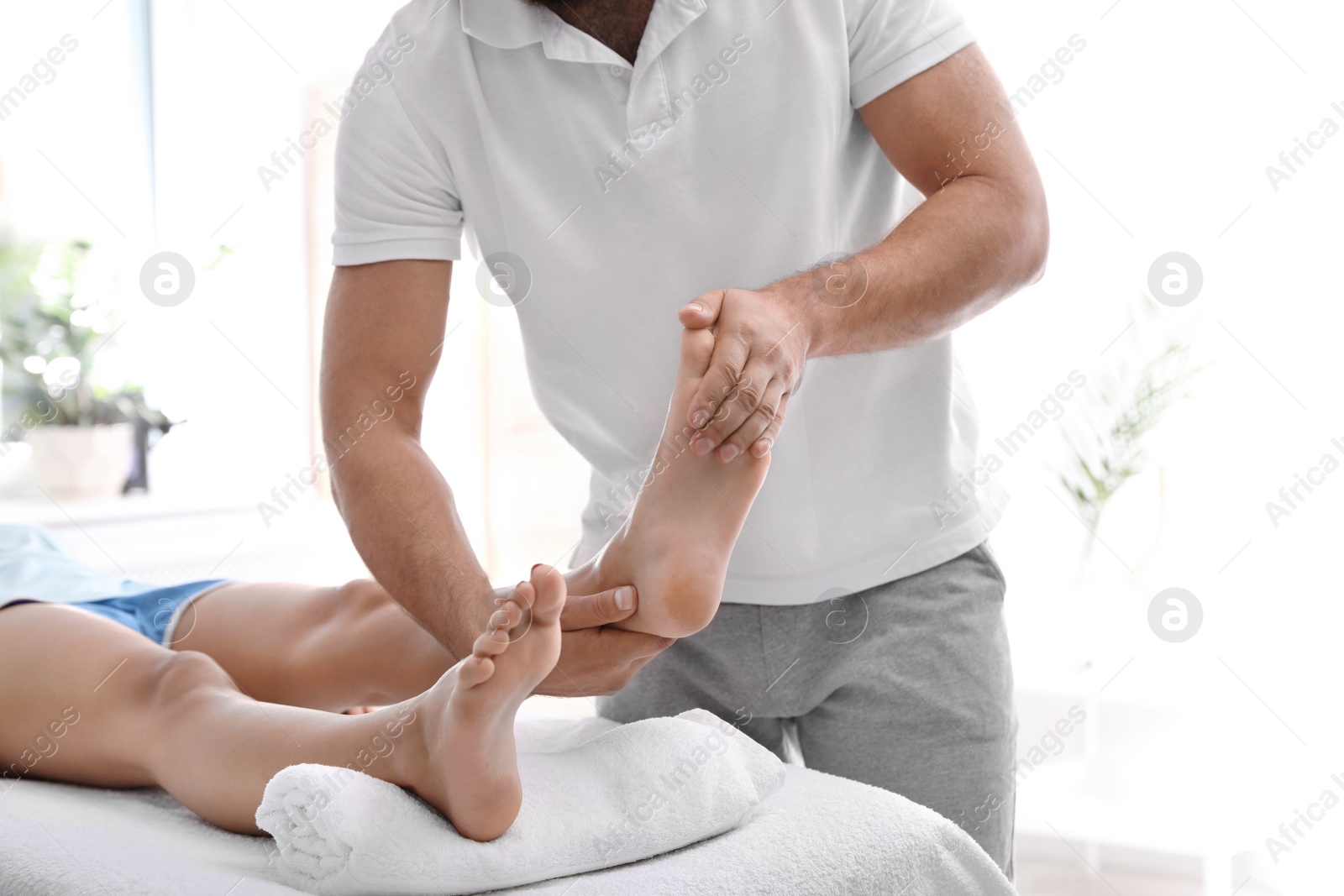 Photo of Young woman receiving massage in salon, closeup