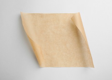 Sheet of brown baking paper on white background, top view