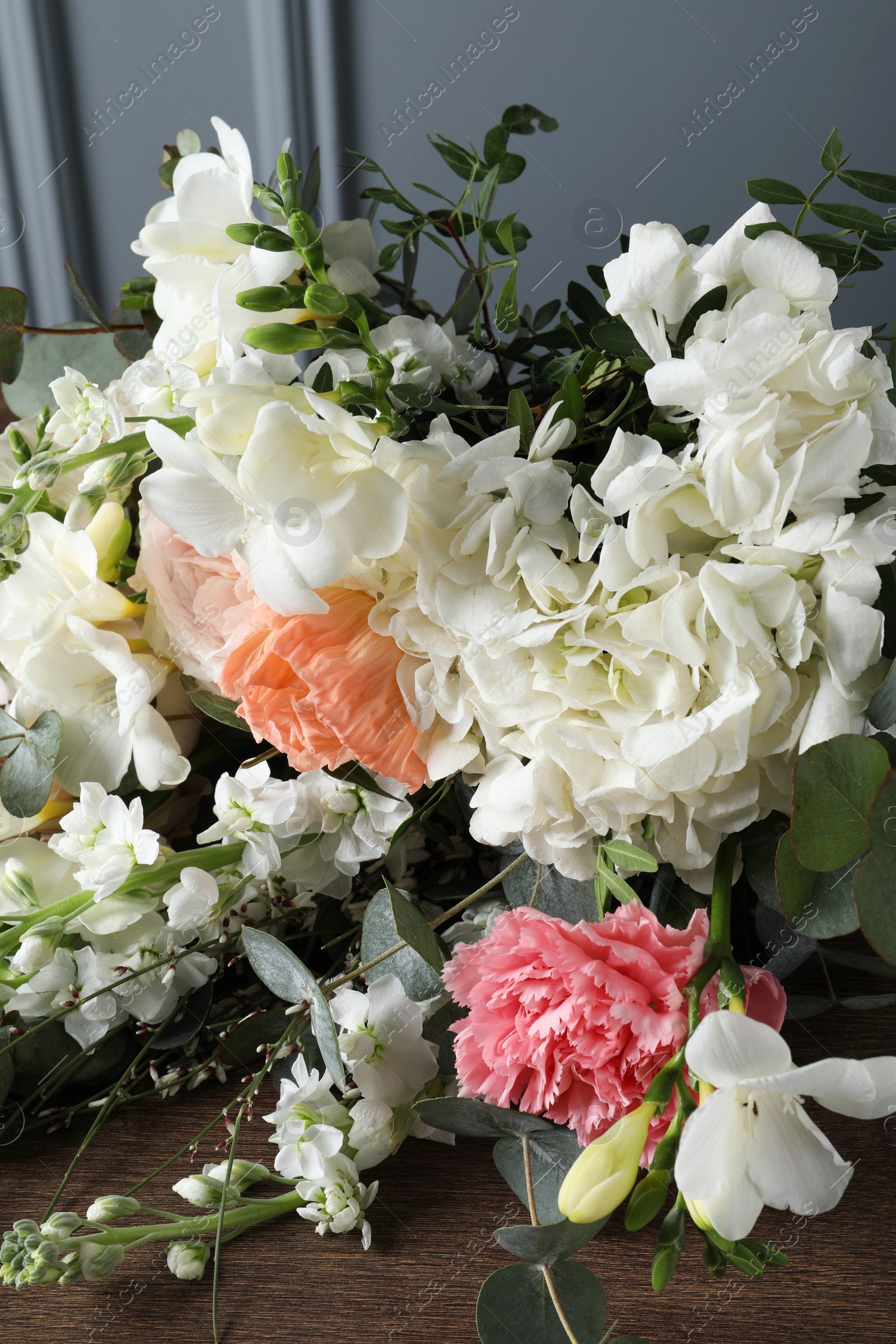 Photo of Bouquet of beautiful flowers on wooden table, closeup