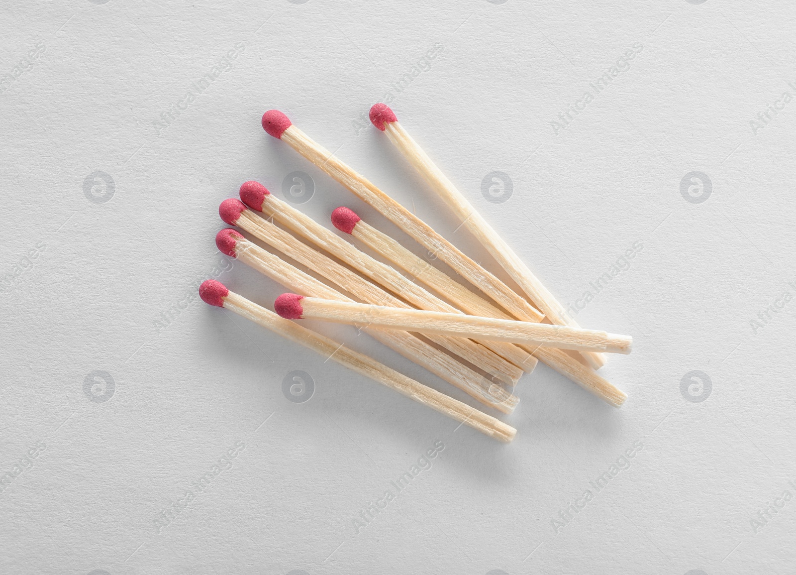 Photo of Pile of wooden matches on white background, top view