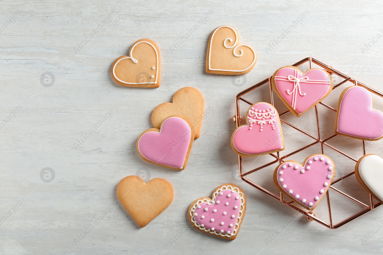 Photo of Flat lay composition with decorated heart shaped cookies and space for text on table