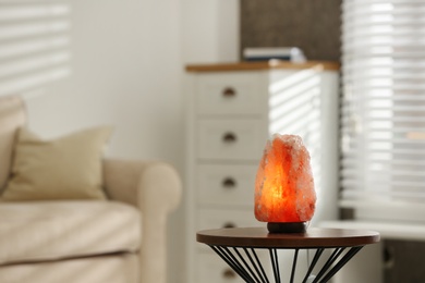 Himalayan salt lamp on table at home, space for text