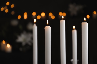 Photo of Burning candles on blurred background. Funeral symbol