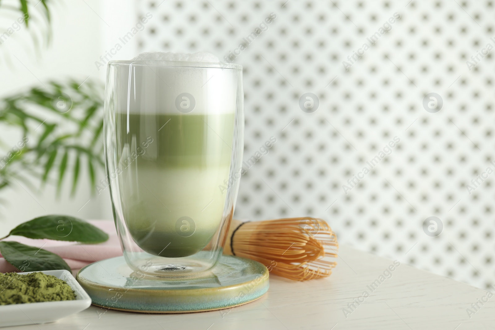 Photo of Glass of tasty matcha latte on light grey table. Space for text