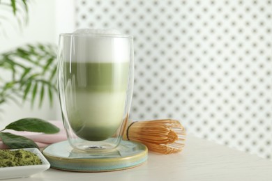 Glass of tasty matcha latte on light grey table. Space for text