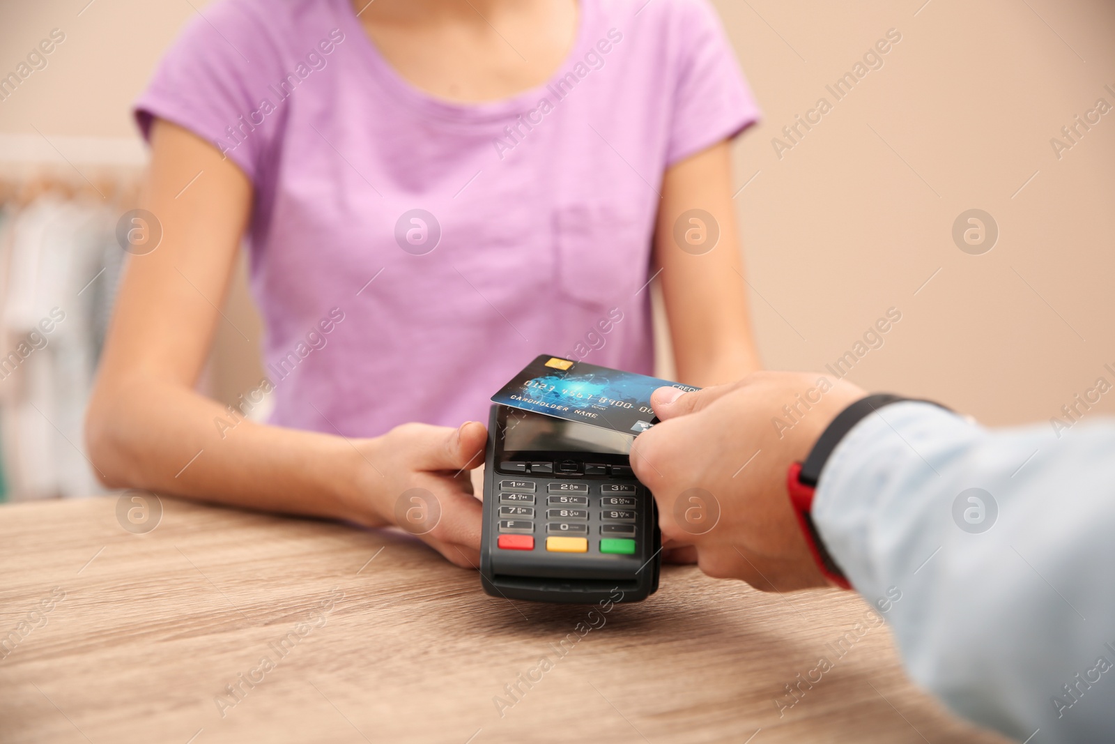 Photo of Man using terminal for credit card payment in shop, closeup