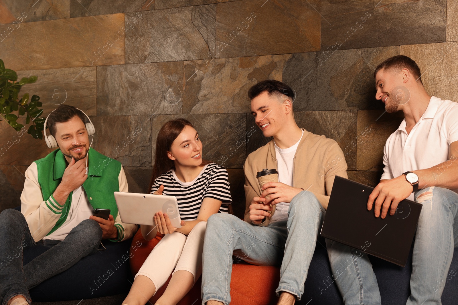 Photo of Office employees enjoying break together in recreation room at work