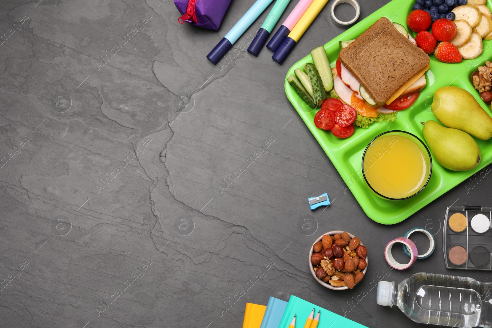 Photo of Flat lay composition with serving tray, tasty healthy food and school stationery on grey table. Space for text