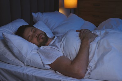 Handsome man sleeping in bed at night