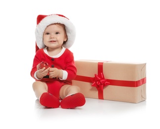 Photo of Cute little baby in Christmas costume and gift on white background