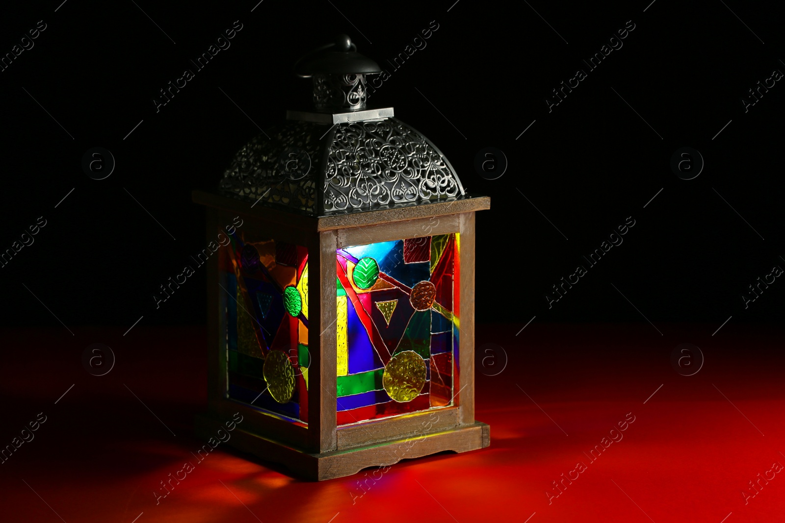 Photo of Decorative Arabic lantern on table against dark background