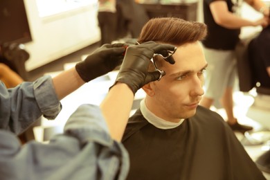 Image of Professional barber working with client in hairdressing salon