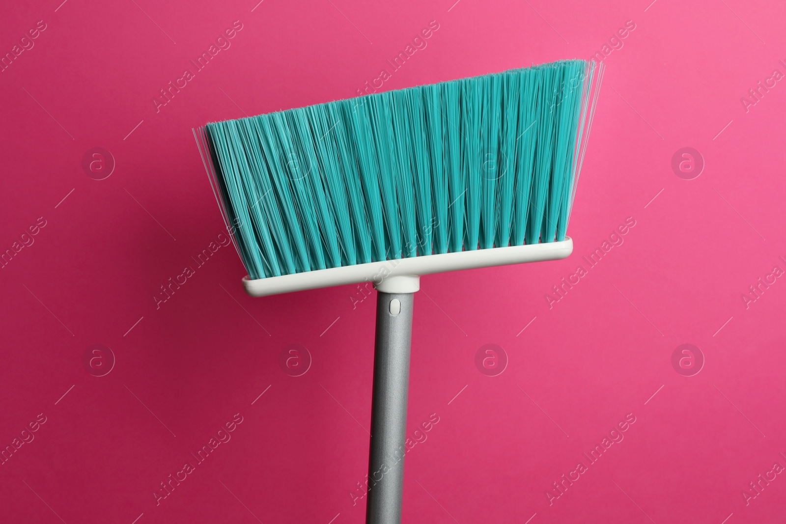 Photo of Plastic broom on pink background. Cleaning tool