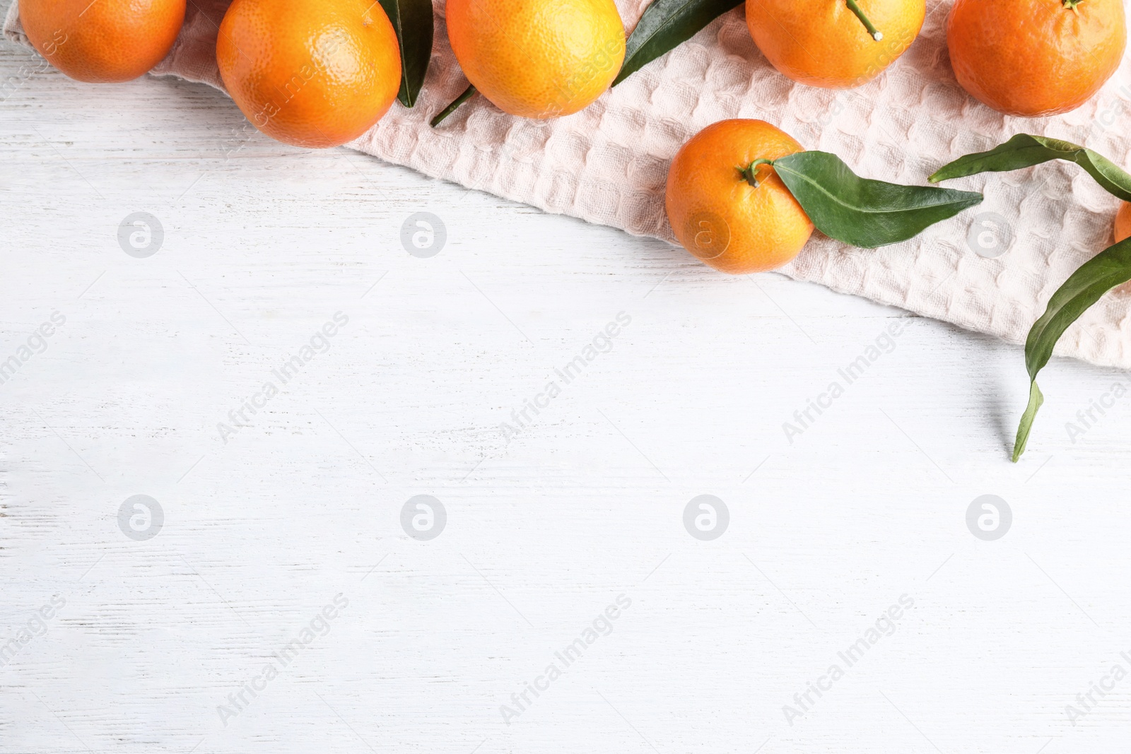 Photo of Fresh ripe tangerines on white wooden table, flat lay. Space for text
