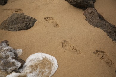 Photo of Child's footprints on sand at sea beach
