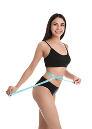 Photo of Attractive young woman with slim body measuring her waist on white background