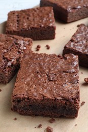 Delicious chocolate brownies on parchment paper, closeup