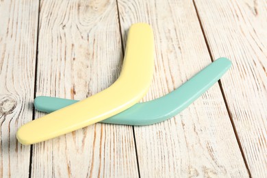 Photo of Color boomerangs on white wooden background. Outdoors activity