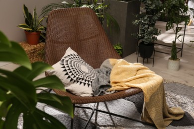 Photo of Lounge area interior with comfortable armchair and beautiful houseplants
