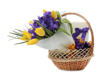 Photo of Wicker basket with gift, bouquet and candies on white background