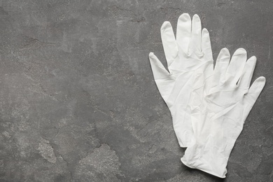 Pair of medical gloves on grey background, flat lay. Space for text