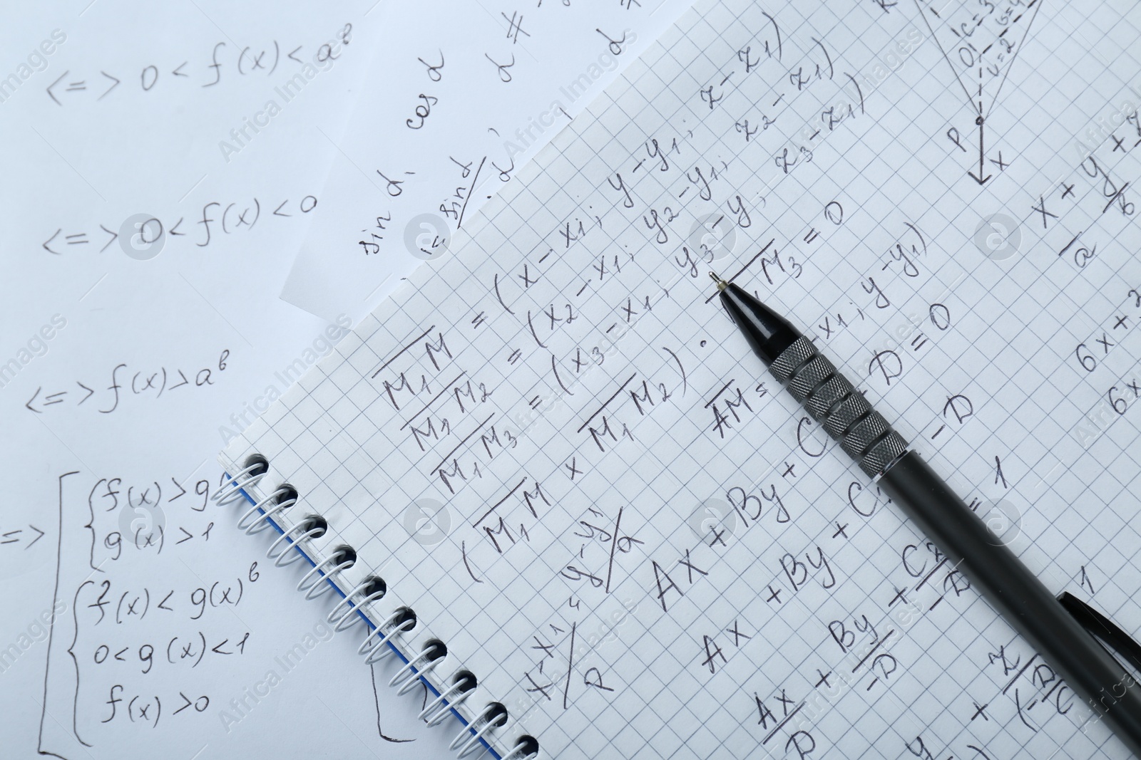 Photo of Notebook with different mathematical formulas and pen, top view