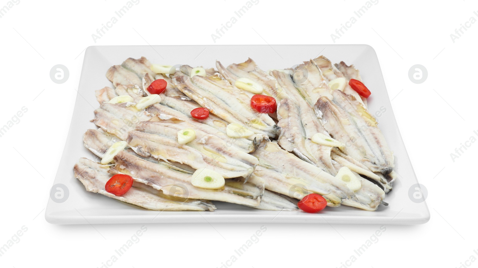 Photo of Tasty pickled anchovies with garlic and chili pepper isolated on white